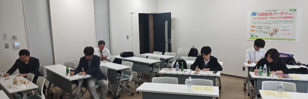 机に向かいワークシートに記入する参加者たち